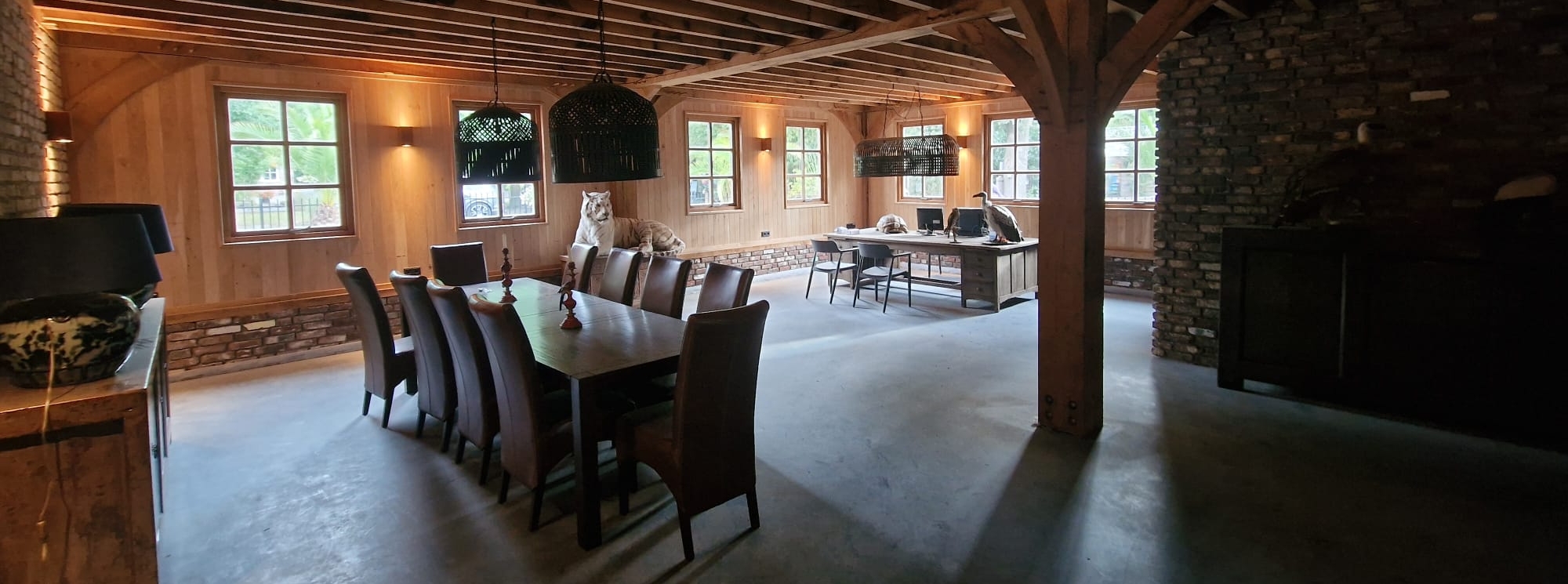 Eiken tafel in sfeervol houten interieur met balkenplafond en werkruimte