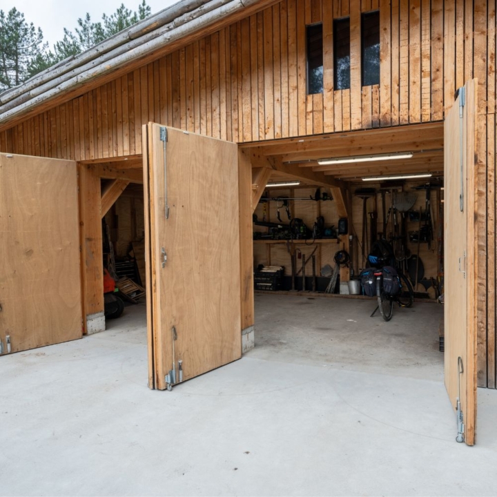 Houten bijgebouw met openslaande deuren voor opslag en buitenruimte