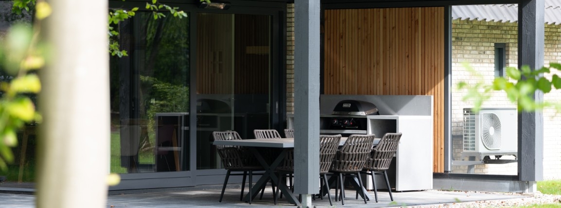 Modern houten bijgebouw met plat dak, overdekt terras en buitenkeuken