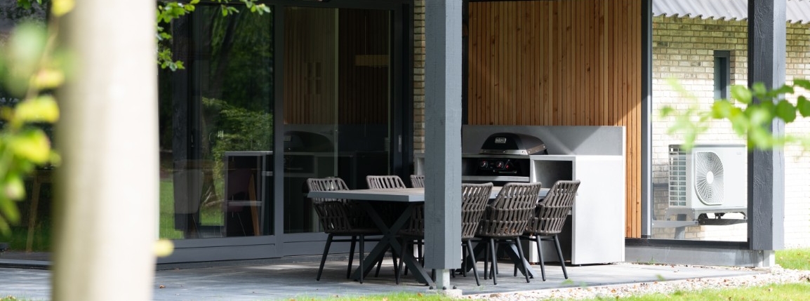 Houten overkapping met buitenkeuken, eettafel en barbecue
