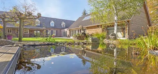 Landelijk poolhouse naast de woonboerderij en zwemvijver in een groene tuin