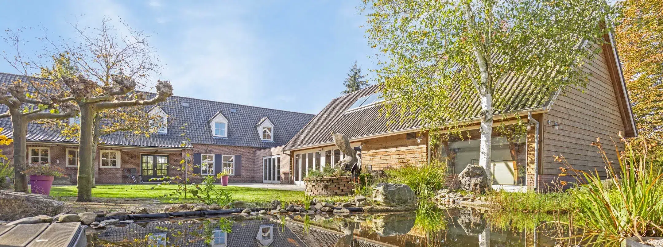 Landelijk poolhouse naast de woonboerderij en zwemvijver in een groene tuin